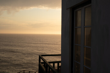 Golden hour views from a window overlooking the ocean