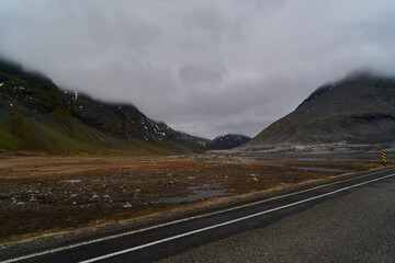 Naklejka premium Empty road crossing a desolate valley in the icelandic highlands