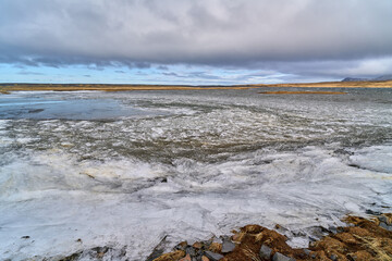 Ice melting on the water surface of a frozen icelandic lake in winter