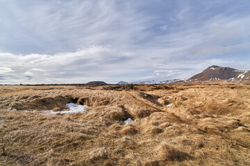 Trail winding through a vast icelandic landscape on a cloudy day