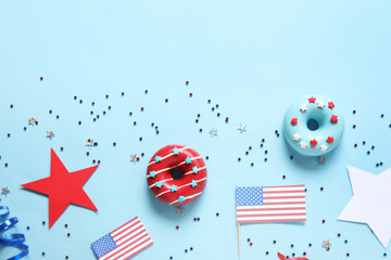 Obraz premium Composition with donuts, USA flags and confetti on blue background. Independence Day celebration