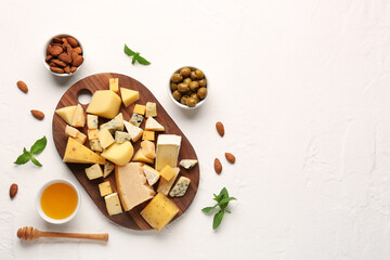 Pieces of tasty cheese, nuts and honey on light background
