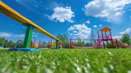A playground with a seesaw and green grass.