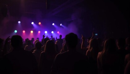 Naklejka premium silhouette of people dancing and having fun under colorful spotlights in a night club 
