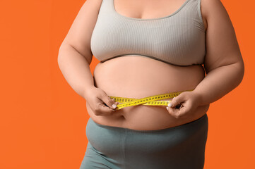 Young overweight woman with measuring tape on orange background, closeup. Weight loss concept