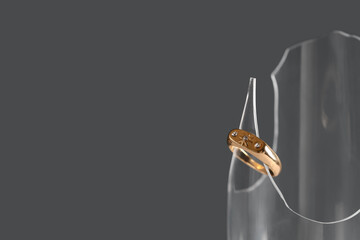 Broken glass with beautiful ring on black background