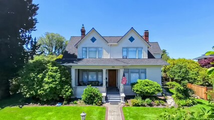 Quaint American suburban home exterior; departure drone point of view