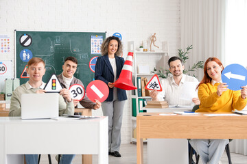 People with traffic signs and instructor at driving school