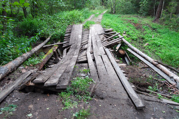 Old dilapidated wooden bridge on a forest road