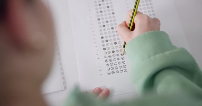 Student, quiz and writing answer on test for education, learning and knowledge at school with top view. Assessment, person and multiple choice questionnaire for exam, studying or evaluation in class