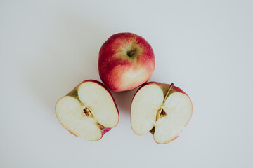 red full and cut in half apples on white background
