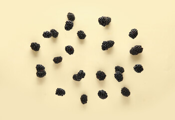 Tasty blackberries flying on beige background