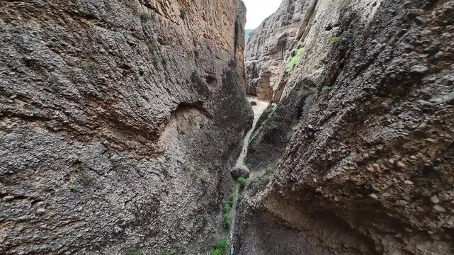 Aerial-First Person View-Flying fast through narrow slot canyon erosion carved in conglomerate material that leaves hand holds making for a world class rock climbing experience in Maple Canton, Utah