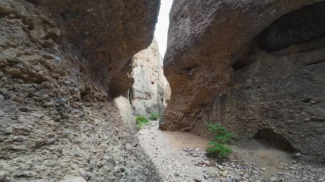 Aerial-FPV-Flying over the trail in narrow slot canyon comprised of sedimentary conglomerate rocky material that make ideal hand holds making the canyon a world class rock climbing area - Maple Canyon