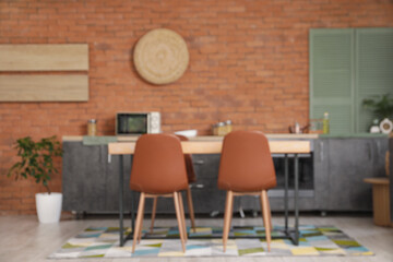 Blurred view of kitchen with black counters and dining table