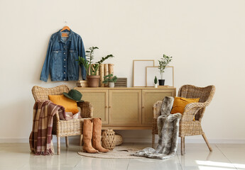 Interior of living room with armchairs, drawers and cowboy hat