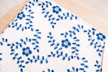 Detailed view of a white fabric adorned with blue floral embroidery, perfect for showcasing craftsmanship in textiles.