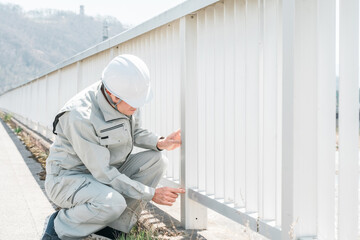 橋梁工事・橋の点検・チェックをする作業員の男性
