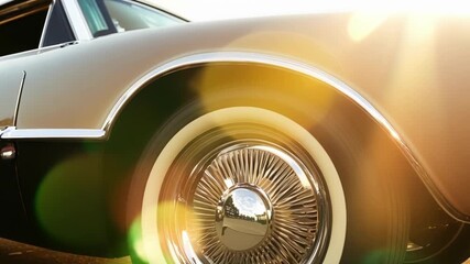 The classic rims of a vintage car catch the light producing elegant lens flares that dance across its surface. Light leaks bokeh