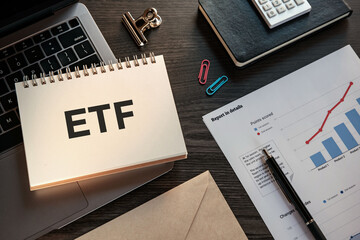 There is notebook with the word ETF. It is an abbreviation for Exchange Traded Funds as eye-catching image.