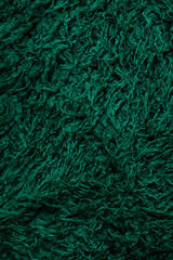 A detailed close-up shot of a richly textured green fabric.