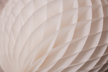 A detailed close-up of a white paper honeycomb decoration