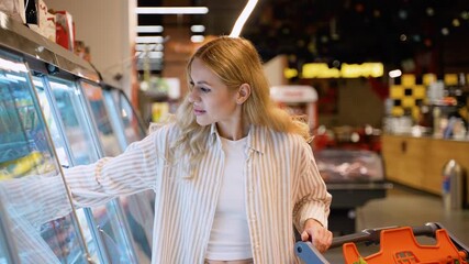 Beautiful blonde woman shopping cheese in grocery store