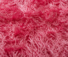 A close-up of a bright pink fluffy rug, showcasing its soft and luxurious texture.