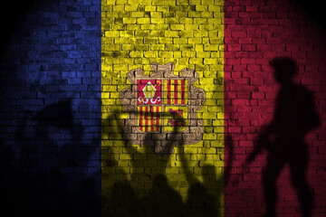 andorra flag on brick wall and protesters shadow