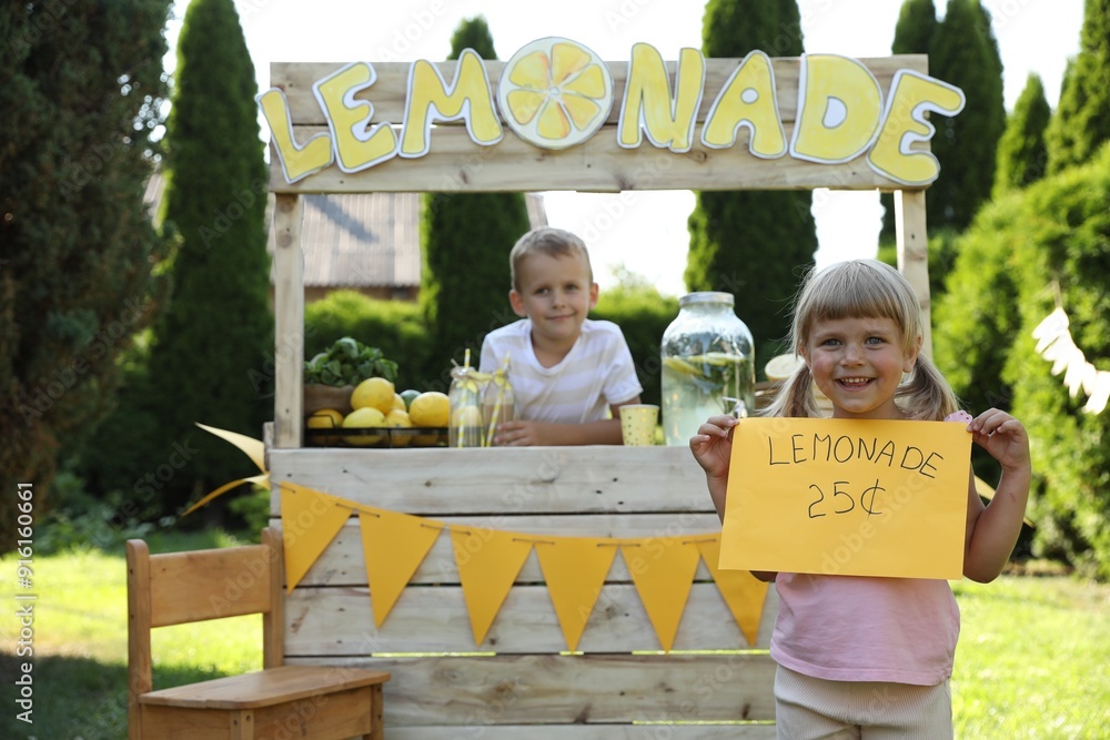 Canvas Prints Little girl holding price tag near lemonade stand in park