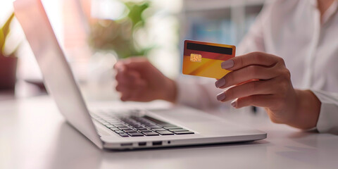 A woman is using a laptop to pay for something with a credit card. Concept of convenience and modernity, as the woman is able to complete a transaction without having to physically hand over cash