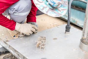 Worker wear clamp nut on cover pit.