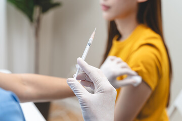 People getting a vaccination to prevent pandemic concept. Woman in medical face mask receiving a dose of immunization coronavirus vaccine from a nurse at the medical center hospital