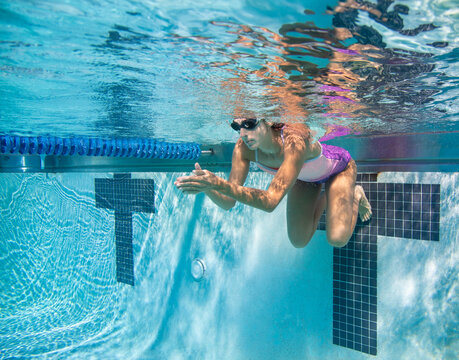Underwater shot of a young woman  swimming front crawl in a swimming pool