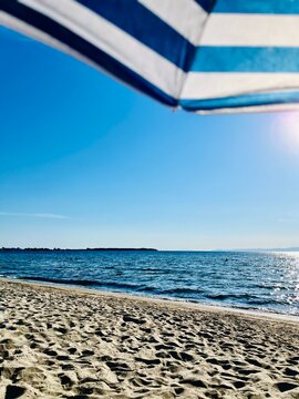 Striped parasol on an empty beach in summer, Thassos, Aegean islands, Greece