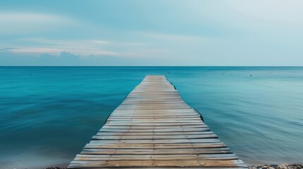 Fototapeta premium Wooden Pier Extending into Calm Blue Ocean at Dusk