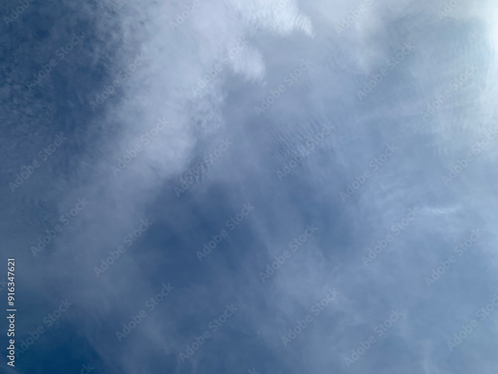 Wall mural an image of a sky with thinly scattered white clouds and bright light.