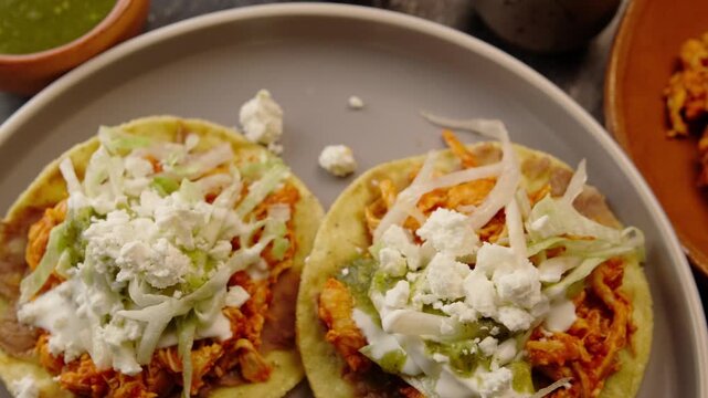 Chicken tinga tostadas on a round gray ceramic plate, top view