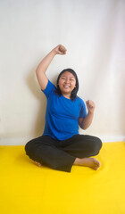Fototapeta premium Young Girl Sitting Crossed Legs On The Floor While Stretching Arms And Back at Home