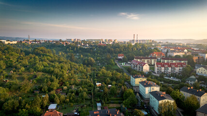 Cityscape view from above with greenery and residential buildings during sunset