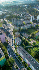 Aerial view of a suburban residential area with colorful buildings and green spaces on a sunny day