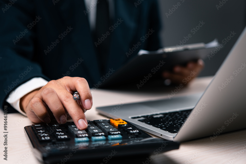 Aufkleber business professional calculating financial data using a calculator and laptop. suitable for financi