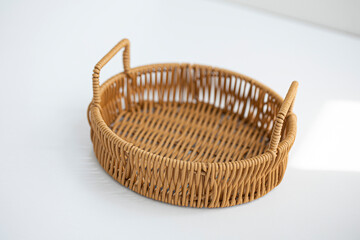 Round wicker basket on white background.