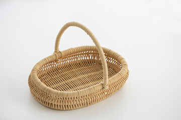 Round wicker basket on white background.