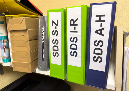 SDS binders on a shelf in an OSHA compliant workplace.
