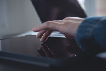 Close up of  woman finger touching on digital tablet screen during online working on laptop computer on office table, searching data on internet network