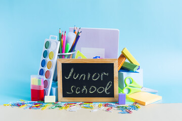 A large set of school supplies and an inscription on the board 