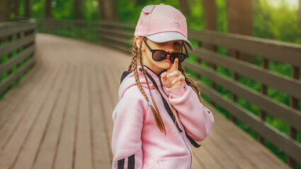 Beautiful hipster girl walking in a nature park wearing sunglasses