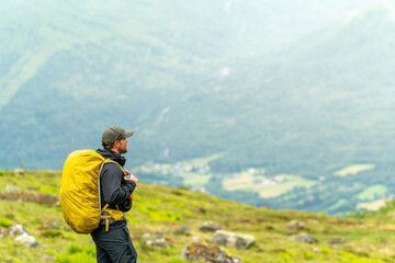 male photographer hiker on the trail in isfjorden fjord in norway on a rainy cold day