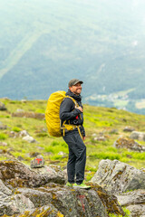 male photographer hiker on the trail in isfjorden fjord in norway on a rainy cold day